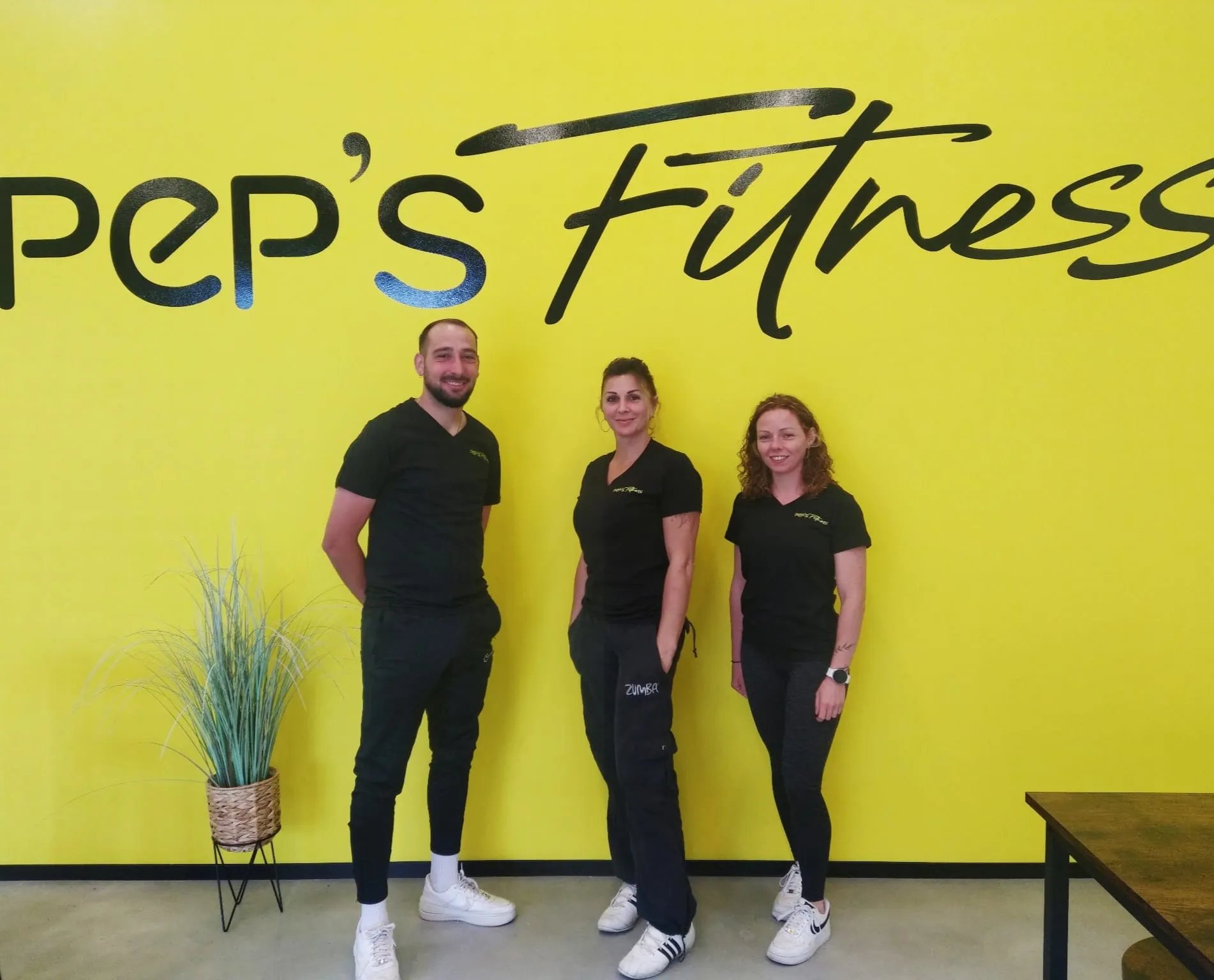 L'équipe de Pep's Fitness devant le logo de la salle